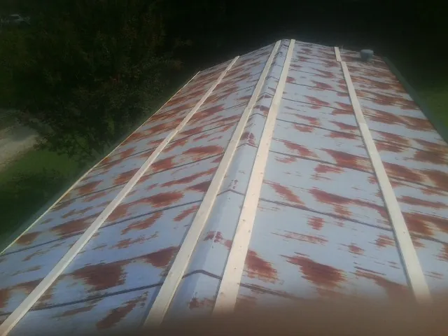 Rusted metal roof panels with new wood purlins before replacement — Storm Damage Roof Repair in Council by Roofing Brothers